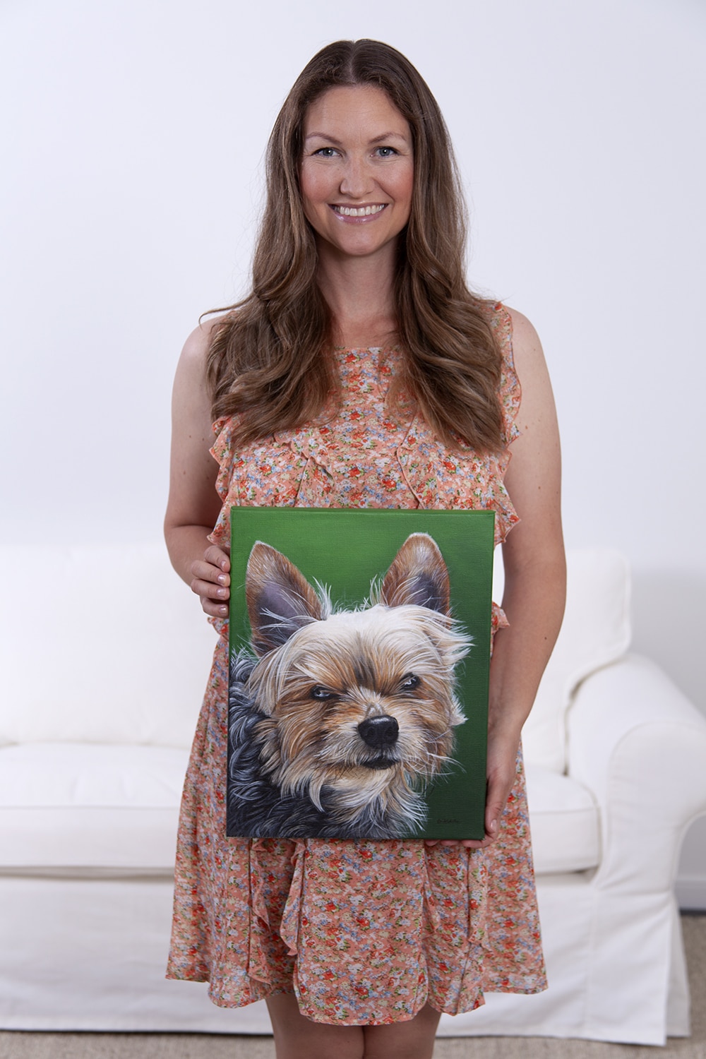 Fine arts painter Erica Eriksdotter holds a custom dog portrait of a yorkshire terrier