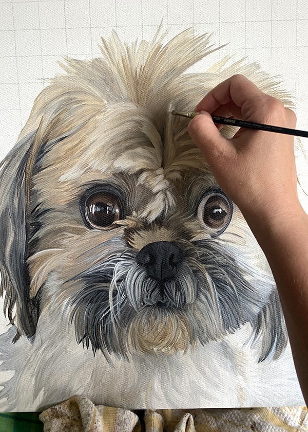 Close-up of artist, Erica Eriksdotter, painting a portrait of a dog on canvas.