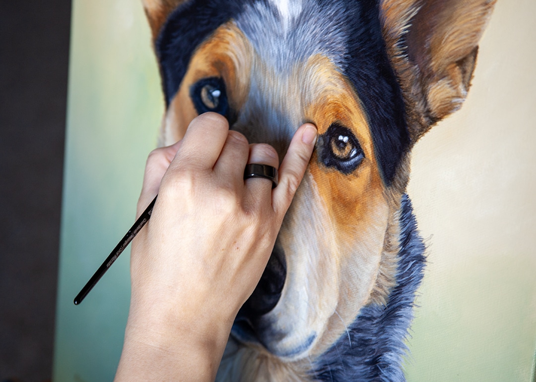 Close-up of Erica Eriksdotter’s hand painting a custom pet memorial portrait, symbolizing healing and emotional connection through art.